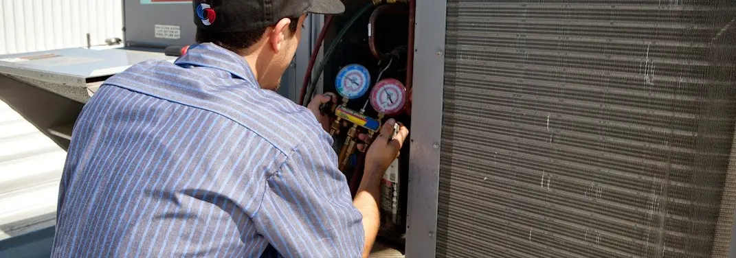 HVAC technician servicing a condenser unit in Choctaw