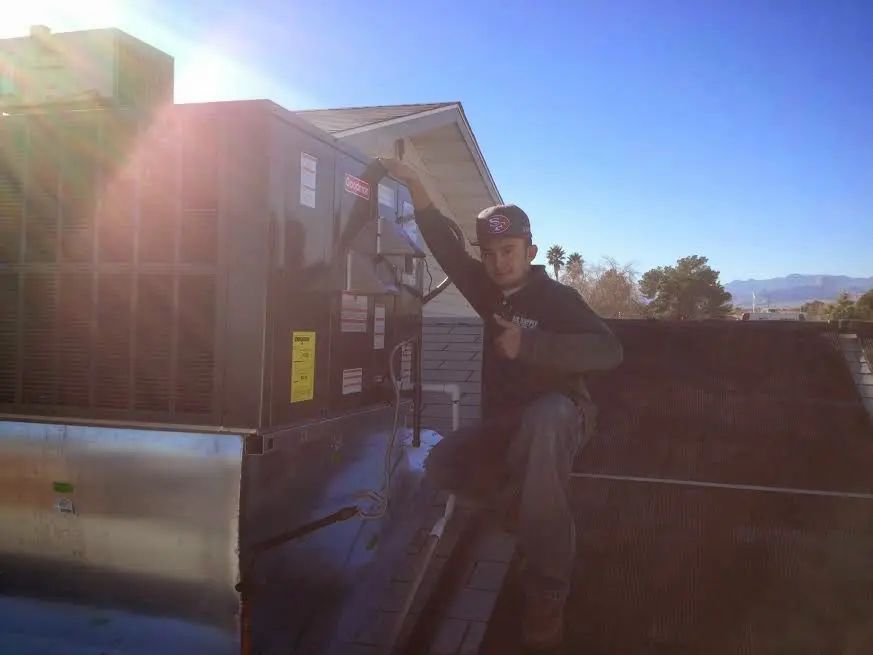 HVAC technician performing Heat Pump Repair on a rooftop unit in Choctaw